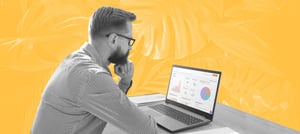 Homem sentado em frente a uma tela de computador analisando as métricas de vendas em HubSpot