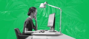 Mulher sentada em frente a uma mesa com um computador realizando gestão integrada de resultados com Hubspot