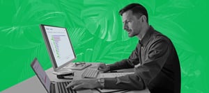 Homem de camisa em frente ao computador usando dashboards de vendas - Tropical Hub