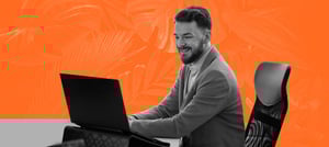 Homem sentado em uma cadeira, em frente a um notebook, verificando indicadores de desempenho - Tropical Hub