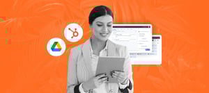 Imagem de uma mulher segurando um tablet nas mãos. Ao fundo, é possível observar duas telas com dashboards de HubSpot e os ícones da HubSpot e do Google Drive, para representar a integração entre as duas plataformas - Tropical Hub