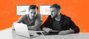 Dois homens trabalhando juntos em um laptop, analisando dados exibidos em gráficos no fundo da imagem. Tropical Hub - HubSpot