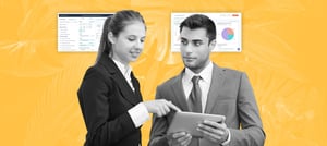 Profissionais analisando dados em um tablet, com painéis digitais ao fundo, representando a Visão 360 do negócio por meio de tecnologia integrada. Tropical Hub - HubSpot